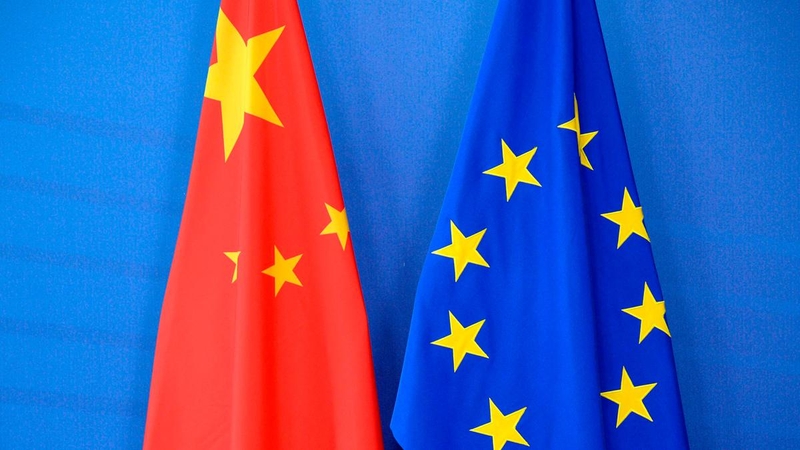 A Chinese flag is draped beside the European Union flag during a EU-China Summit at European Union Commission headquarters in Brussels