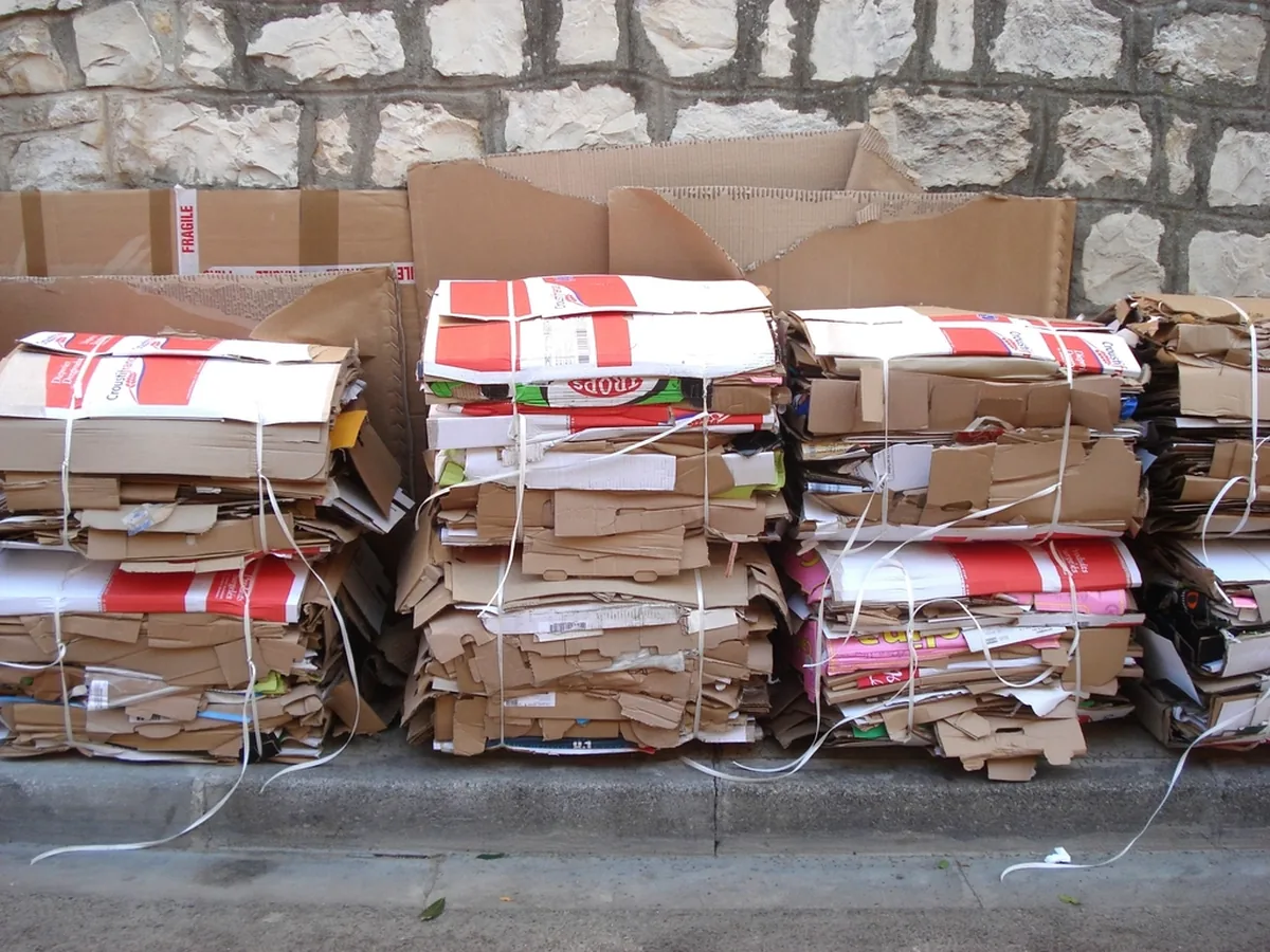 Bundles of flattened cardboard packaging stacked for recycling.
