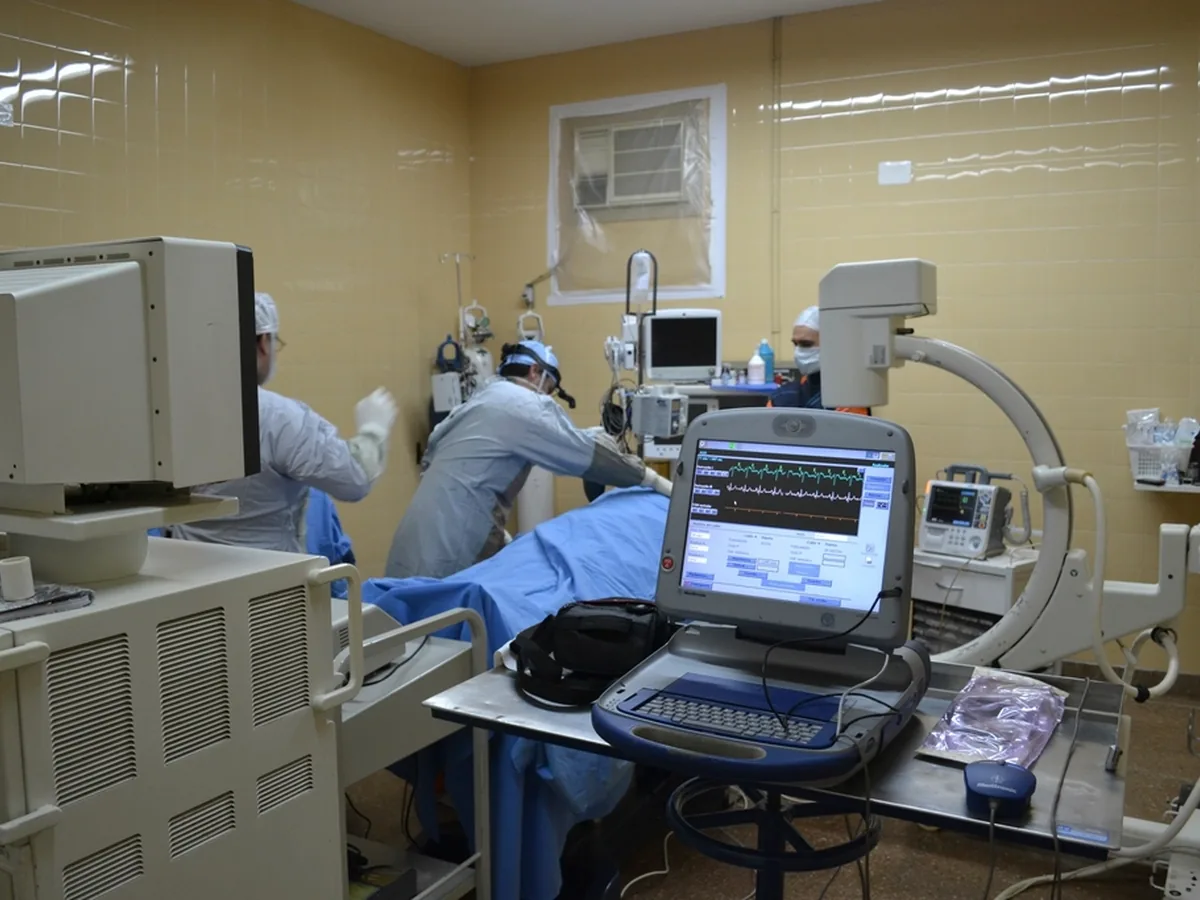 Clinicians using imaging and monitoring equipment in an operating theatre.