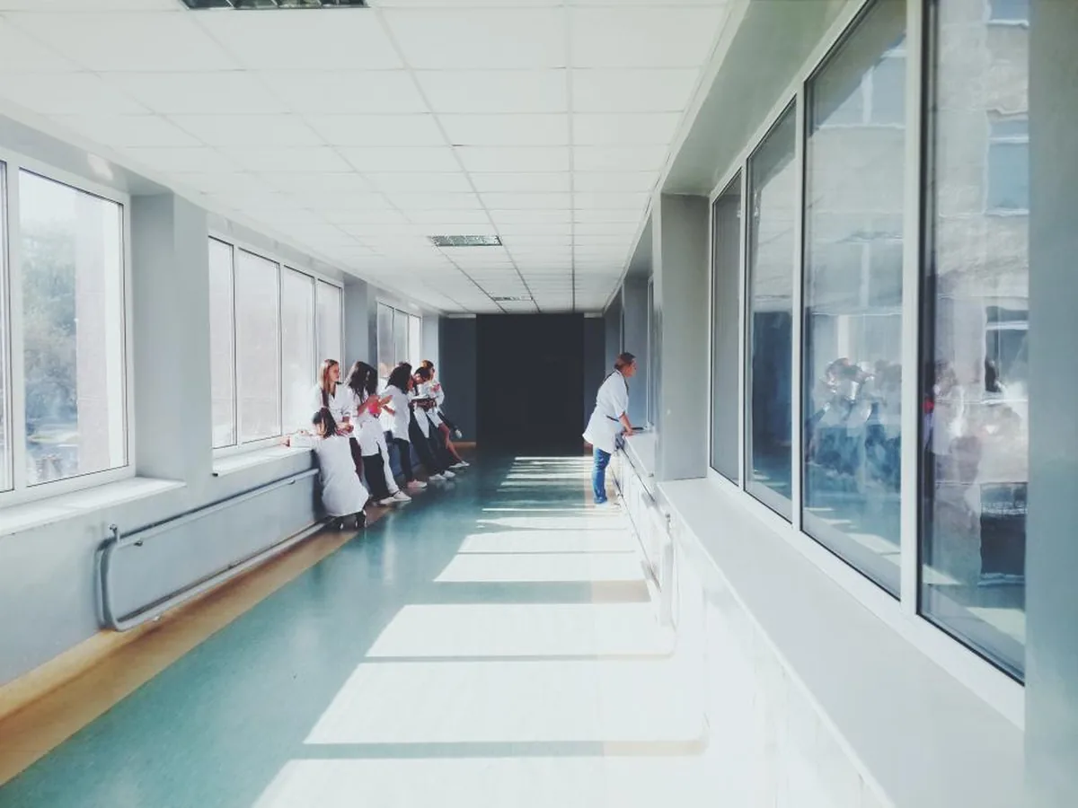 A bright hospital corridor with medical staff at the far end.