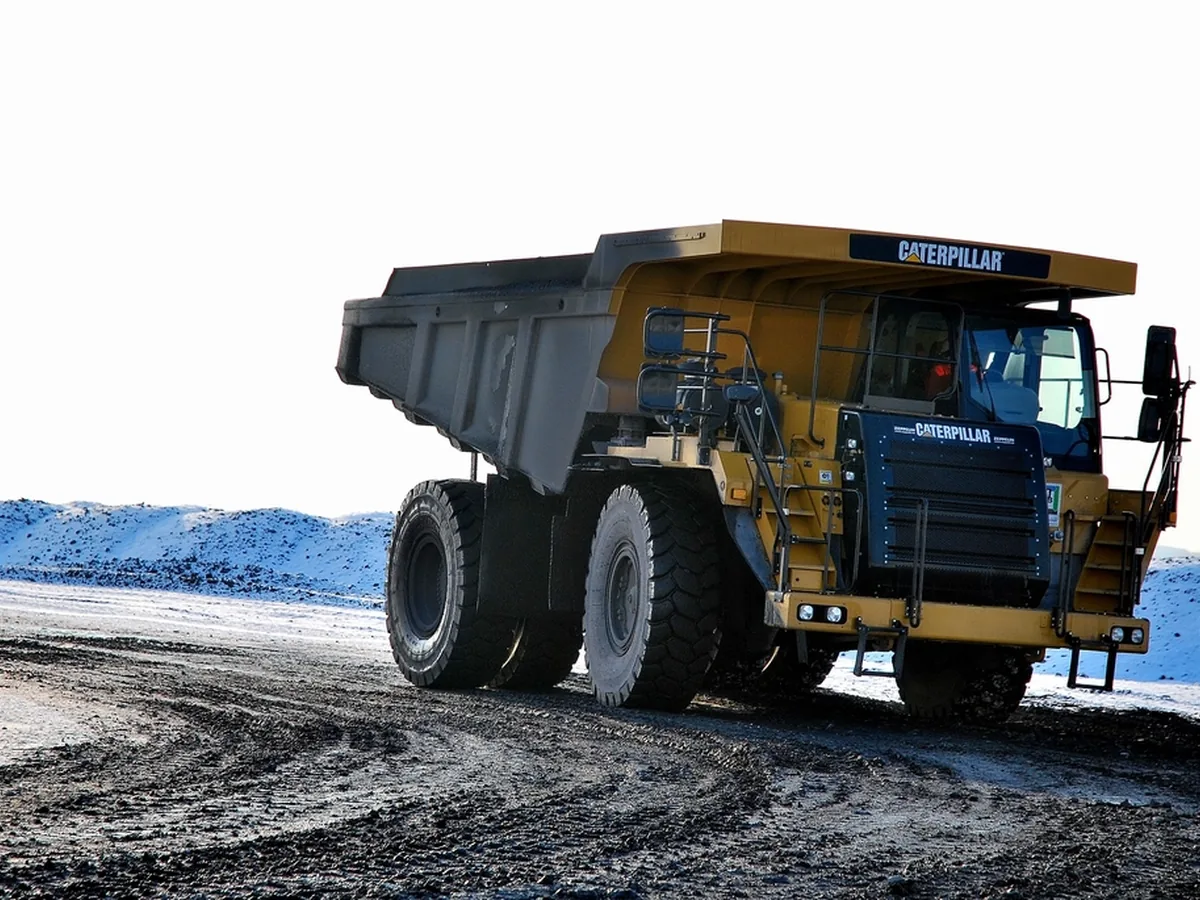 A large haul truck driving across a mine site.