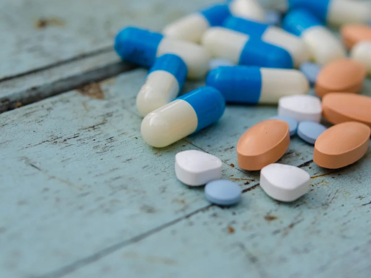Capsules and tablets scattered on a table.