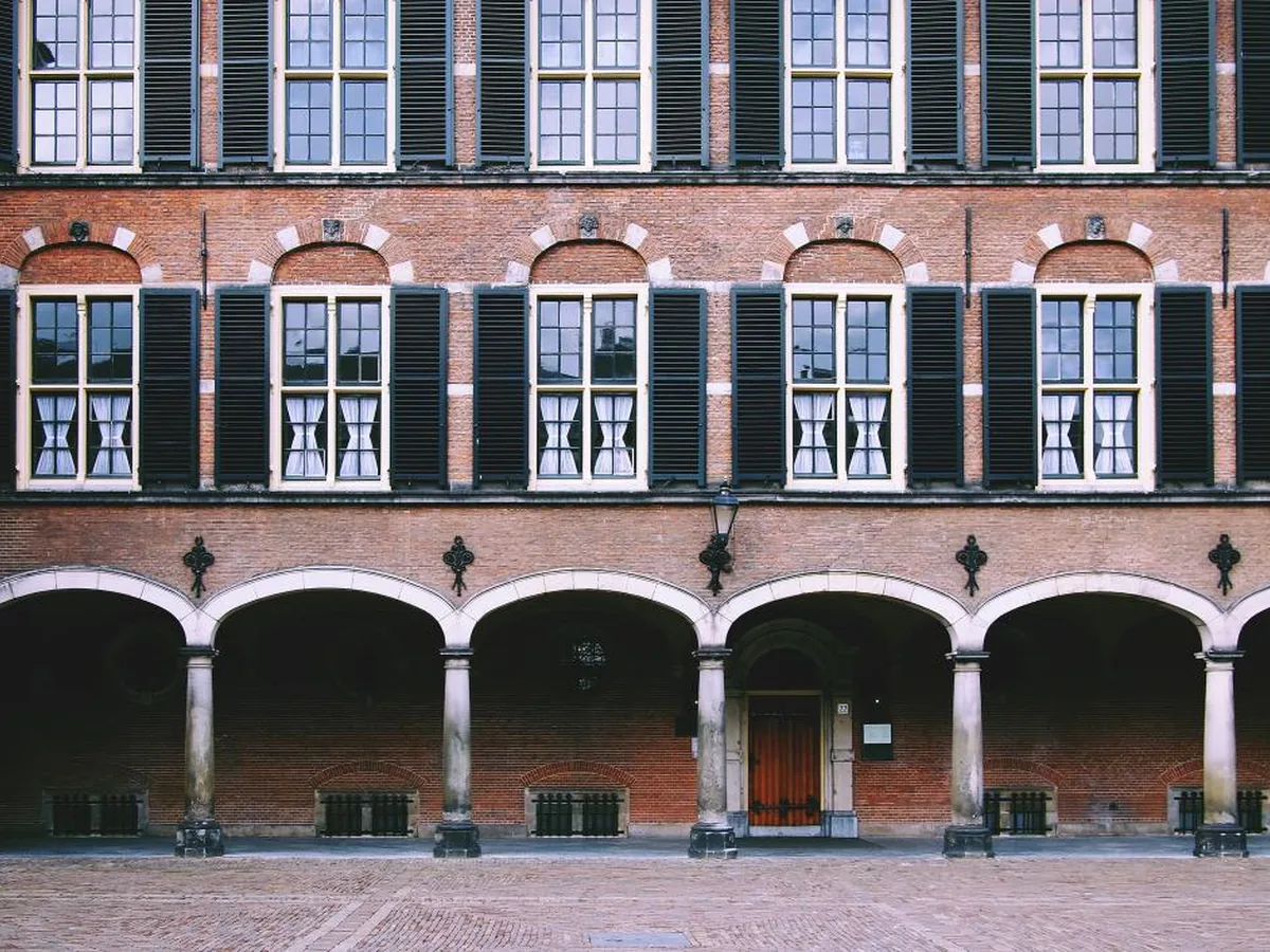 The arched brick courtyard facade of a government building.