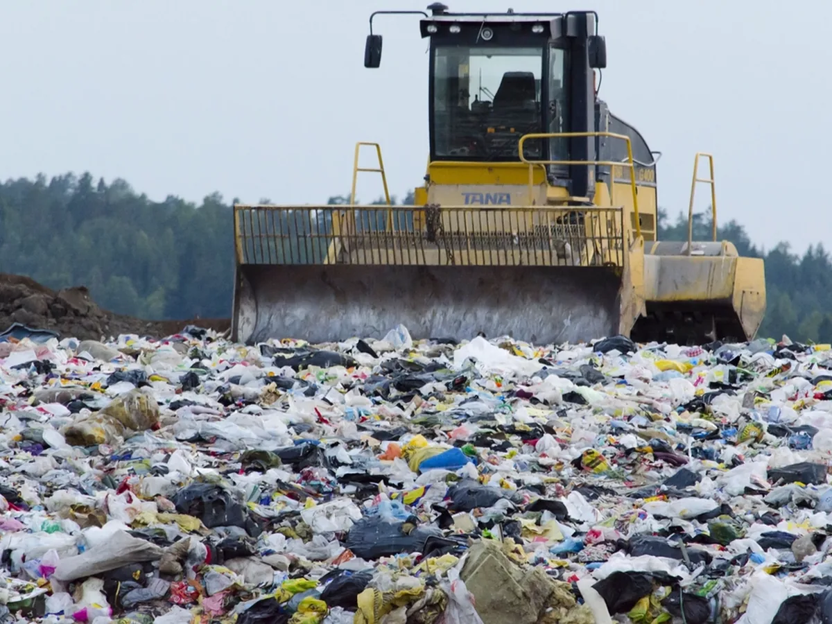 A landfill compactor spreading household waste at a landfill site.