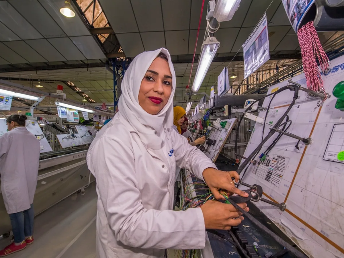 A technician assembles wiring harnesses on a factory production line.